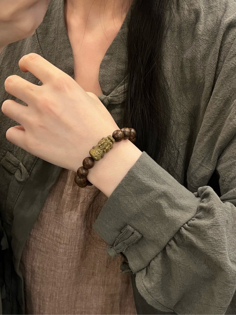 Pixiu bracelet made of golden silk sandalwood.
